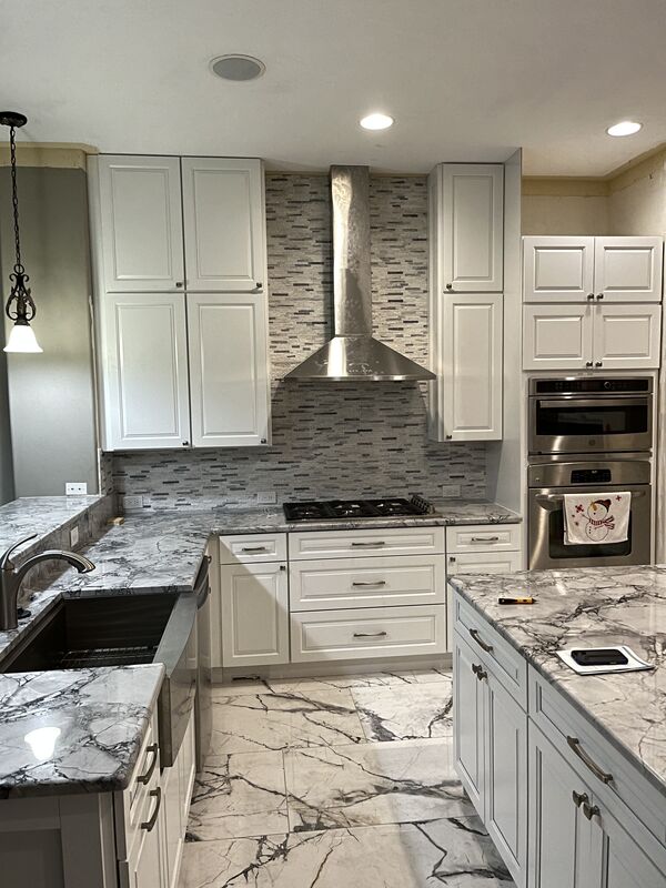 White kitchen with quartzite counters opening into the living space