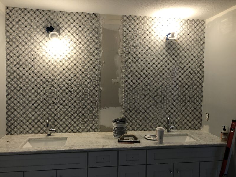Double vanity with a stone counter and framed mirrors in a finished bathroom